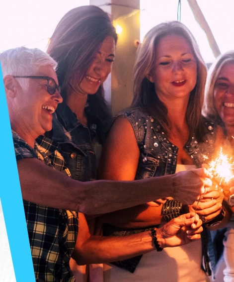 4 smiling women holding a sparkler