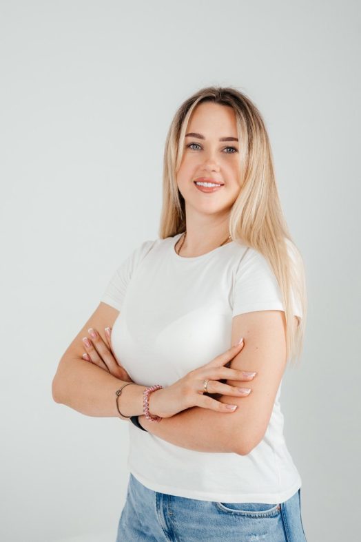 Young woman with blond hair smiling proudly.